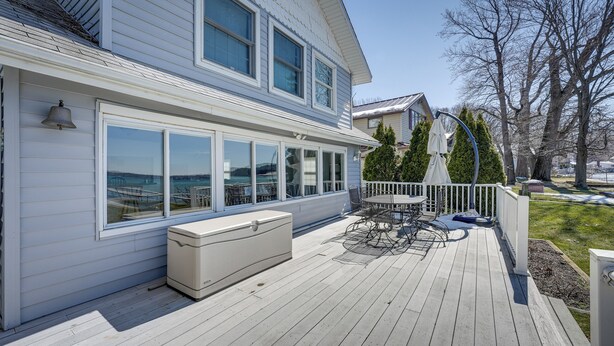 A two-story house with a deck, large windows, and a white exterior. - Lakefront Michigan Cottage - Deck, Grill & Kayaks! (Sturgis)