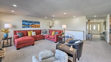 A living room with a red sectional sofa, a coffee table, and a fireplace.