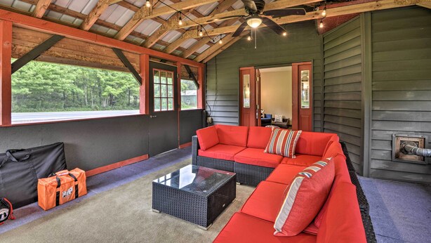 A cozy room with a red sofa, a glass coffee table, and a ceiling fan. - Altmar Family Home w/ Rivers & Trails Nearby! (Altmar)