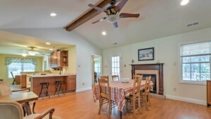 A spacious living room with hardwood floors, a dining area with a table set for four, and a kitchen with wooden cabinets and a bar area. - 'juju's Place' Warsaw House w/ Deck & Tree Swings! (Warsaw)