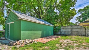 A green garage with a red and black patterned rug in front.