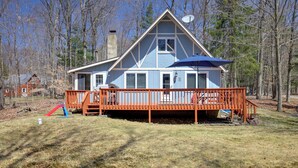 A two-story house with a wooden deck and a satellite dish. - Walk to Beach: Pocono Lake Cabin w/ Pool Access! (Pocono Lake)