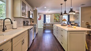 A kitchen with a central island, wooden flooring, and pendant lighting. - Cozy Retreat w/ Hot Tub & Fire Pit: Close to Main! (Fredericksburg)