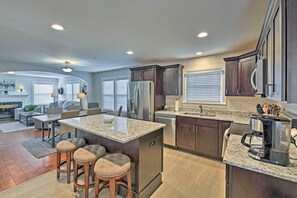A modern kitchen with granite countertops, stainless steel appliances, and dark wooden cabinets. - Indianapolis Vacation Rental - Walk to the Ims! (Indianapolis)