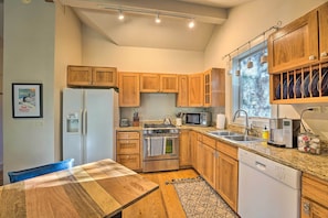 A modern kitchen with wooden cabinets, stainless steel appliances, and a large window providing natural light. - Ketchum Couple's Retreat: 1 Mi to Sun Valley! (Ketchum)