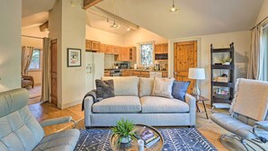A cozy living room with a sofa, armchairs, and a coffee table. There is a kitchen in the background with wooden cabinets and a dining area. - Ketchum Couple's Retreat: 1 Mi to Sun Valley! (Ketchum)