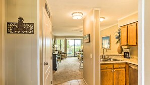 A kitchen with wooden cabinets, a sink, and a coffee maker.