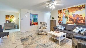 A living room with a sofa, armchair, coffee table, and a ceiling fan. - 7 Mi to Beaches: Pet-friendly Cape Coral Home (Cape Coral)