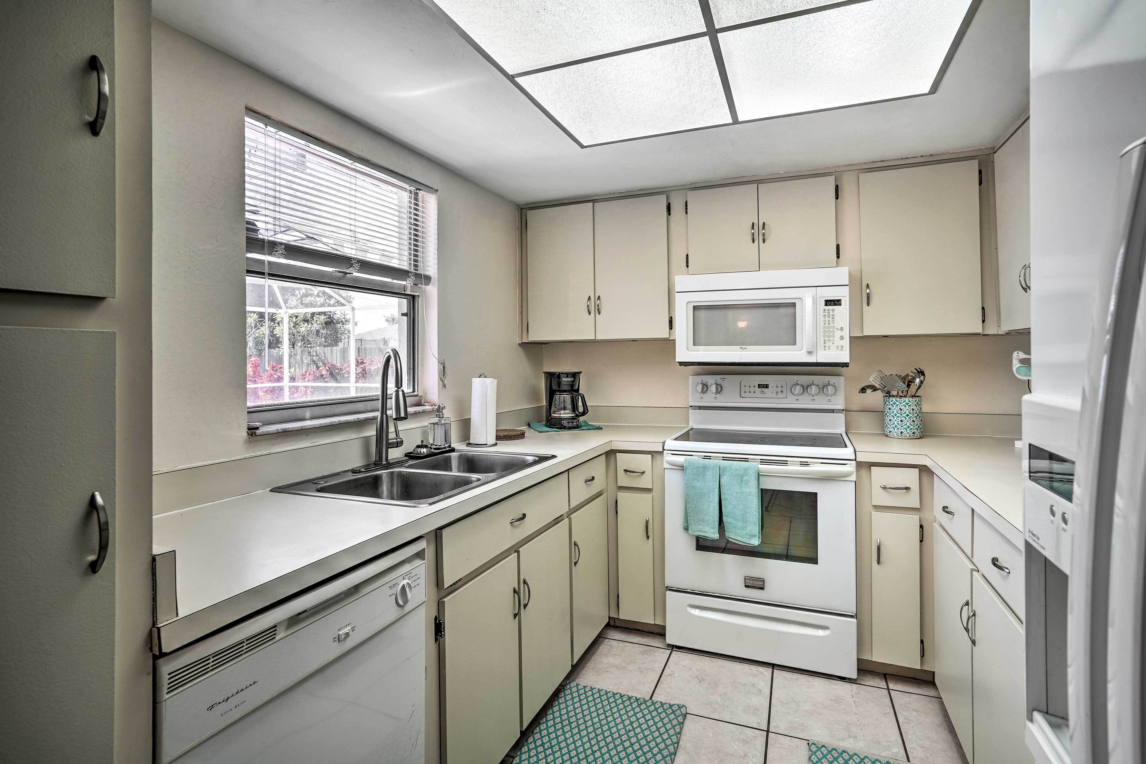 A compact kitchen with a built-in microwave, stove, and sink.