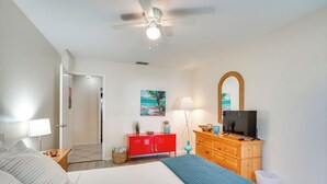 A bedroom with a bed, a red dresser, a television, and a ceiling fan. - 7 Mi to Beaches: Pet-friendly Cape Coral Home (Cape Coral)
