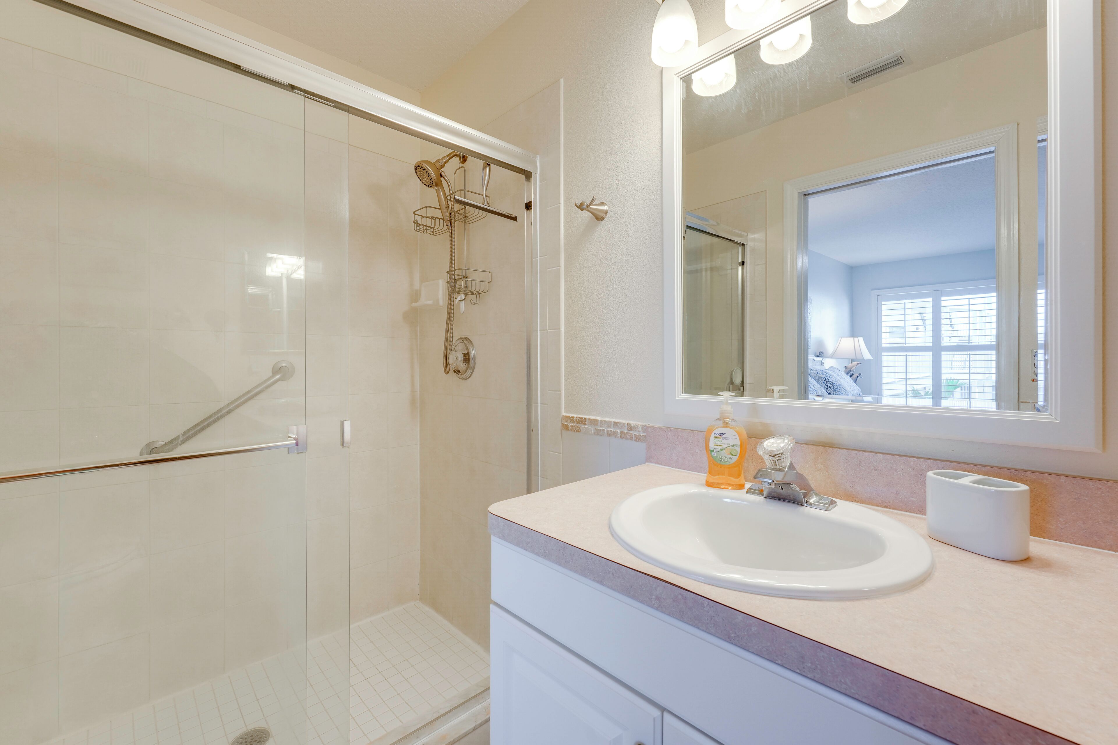 Une salle de bain équipée d’une douche, d’un lavabo, d’un miroir et de toilettes.