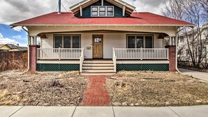 A two-story house with a red roof, white trim, and a front porch with a white railing. - Laramie Home w/ Backyard < 1 Mi to Univ of Wyoming (Laramie)