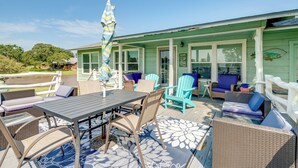An outdoor patio with wicker furniture, a table, and an umbrella. - Pet-friendly Lake Buchanan Retreat w/ Fire Pit! (Tow)