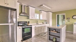 A modern kitchen with white cabinets, stainless steel appliances, and a wooden floor. - Pet-friendly Lake Buchanan Retreat w/ Fire Pit! (Tow)