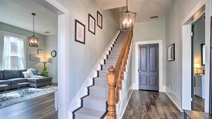 A staircase with wooden balusters and a herringbone carpet, leading to a door. - Spacious Abode, Walk to Texas Heroes Square! (Gonzales)
