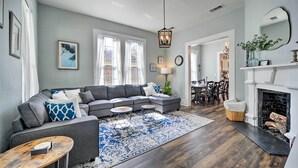 A living room with a gray sectional sofa, a round coffee table, and a fireplace. - Spacious Abode, Walk to Texas Heroes Square! (Gonzales)