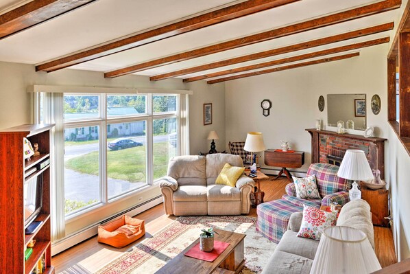 Una sala de estar acogedora con un sofá, sillones, una mesa de centro y una chimenea.