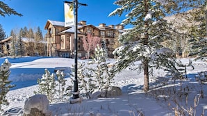 A snow-covered outdoor area with a building featuring a large banner. - Solitude Mountain Slopeside Ski Condo w/ Hot Tub! (Solitude)