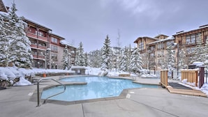 A pool area with a hot tub, surrounded by snow-covered trees and buildings. - Solitude Mountain Slopeside Ski Condo w/ Hot Tub! (Solitude)