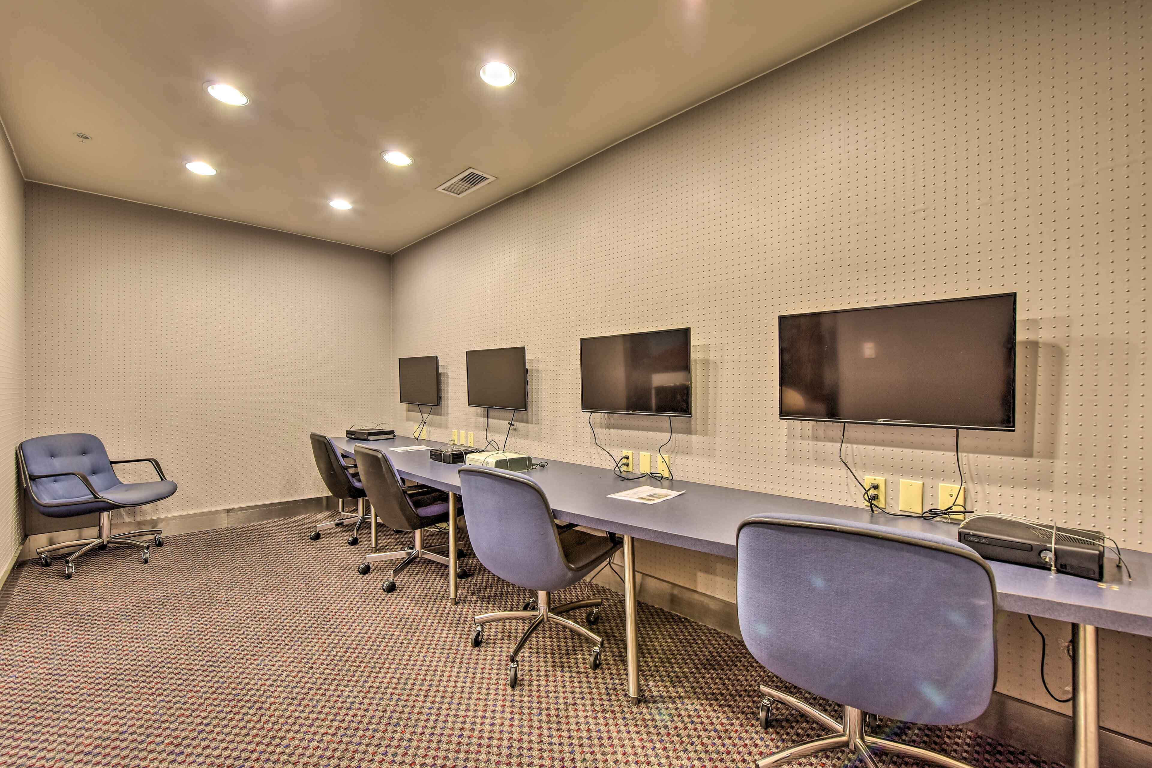 A conference room with a long table, multiple chairs, and three large screens on the wall.