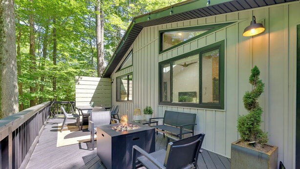 A deck with outdoor furniture, a fire pit, and a potted plant.