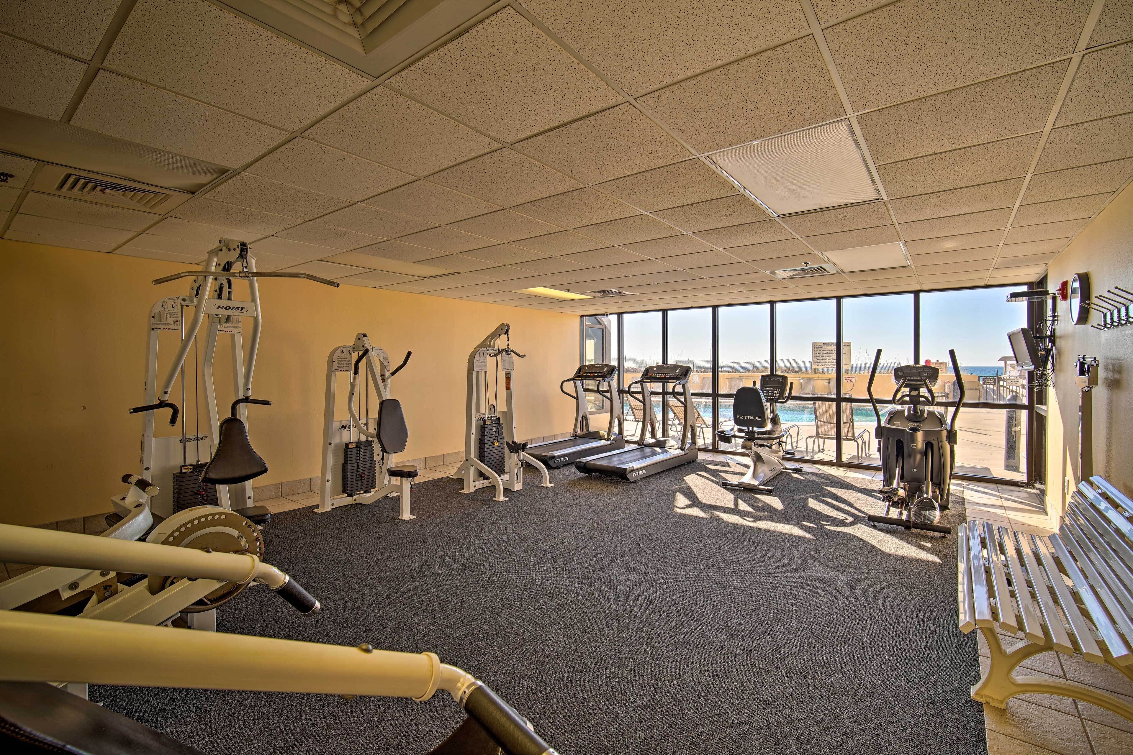 Un gimnasio con máquinas de cardio, pesas y una banca.