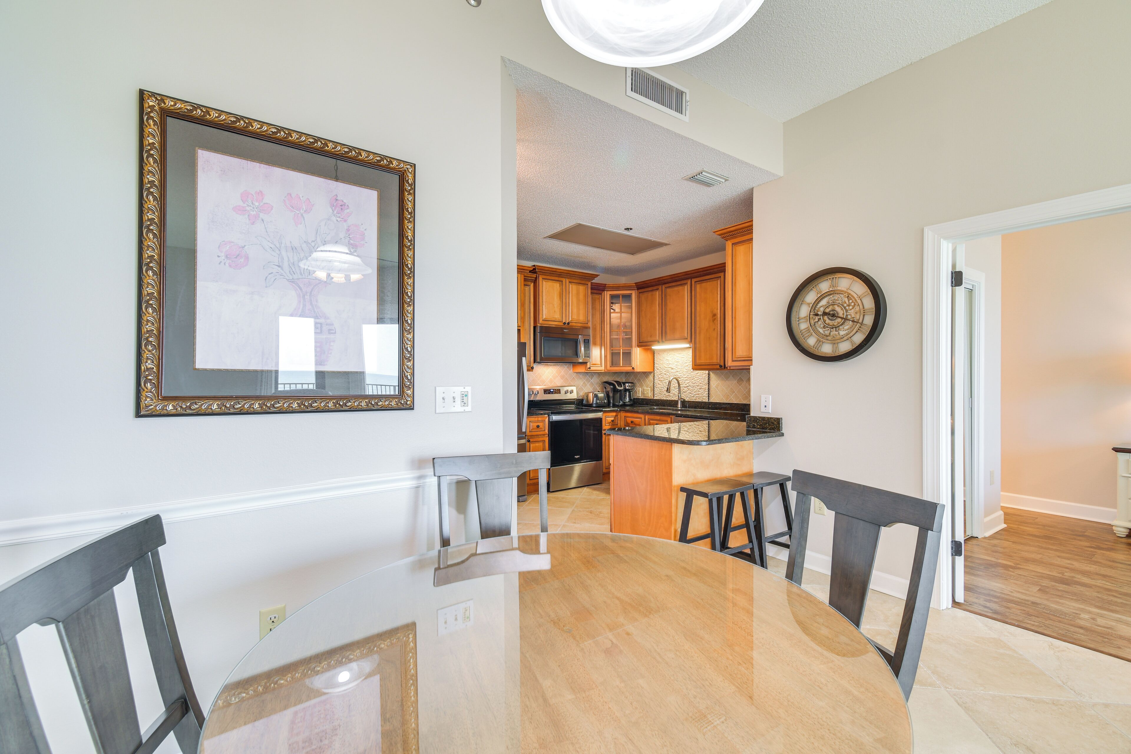 A modern kitchen with wooden cabinets, a stainless steel refrigerator, and a central island with stools.