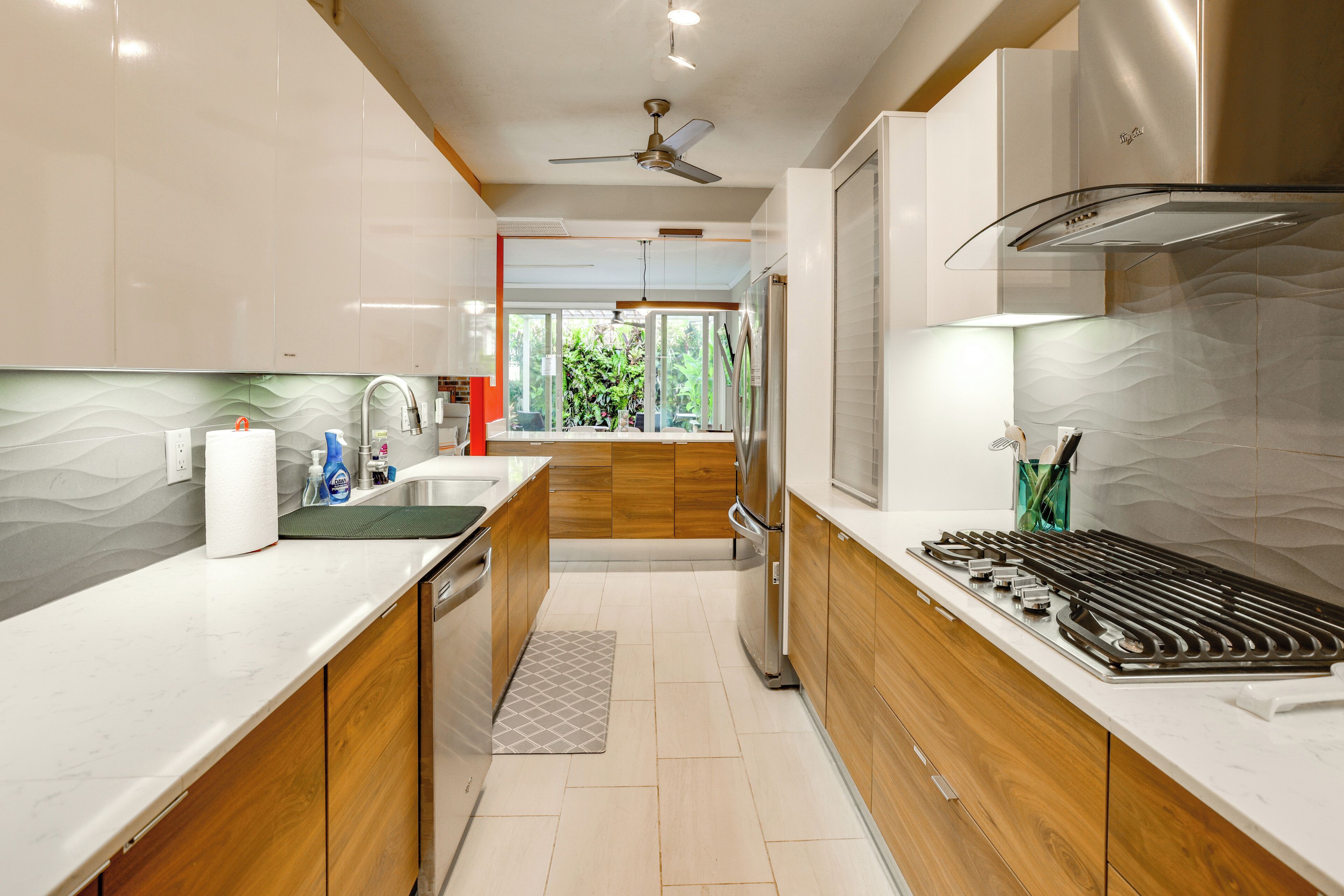 Una cocina moderna con armarios de madera, una estufa de acero inoxidable y vistas al exterior.