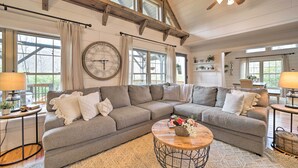 A cozy living room with a large sectional sofa, a round coffee table, and a ceiling fan. - Deck + Fire Pits: Lake Toxaway Getaway! (Lake Toxaway)