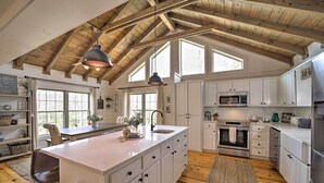 A spacious kitchen with white cabinets, a large island, and a wooden ceiling. - Deck + Fire Pits: Lake Toxaway Getaway! (Lake Toxaway)