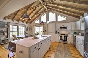 A spacious kitchen with white cabinets, a large island, and a wooden ceiling. - Deck + Fire Pits: Lake Toxaway Getaway! (Lake Toxaway)