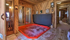 A wooden cabin interior with a hot tub, wooden walls, and a tiled floor. - Secluded Dillon Home w/ Private Hot Tub + Deck! (Dillon)