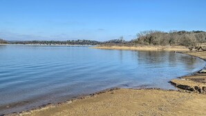 A calm river with a sandy bank and sparse vegetation. - Beaver Lake Home ~ 8 Mi to Downtown Rogers! (Rogers)