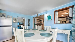 A dining area with a round table, white chairs, and a white refrigerator. - Pet-friendly Hudson Home: Boat Slip, Private Pool (Hudson)