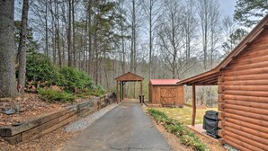 A wooden cabin with a covered porch and a small shed in a forested area. - Rural Murphy Cabin - Yard, Hot Tub & Fire Pit (Murphy)