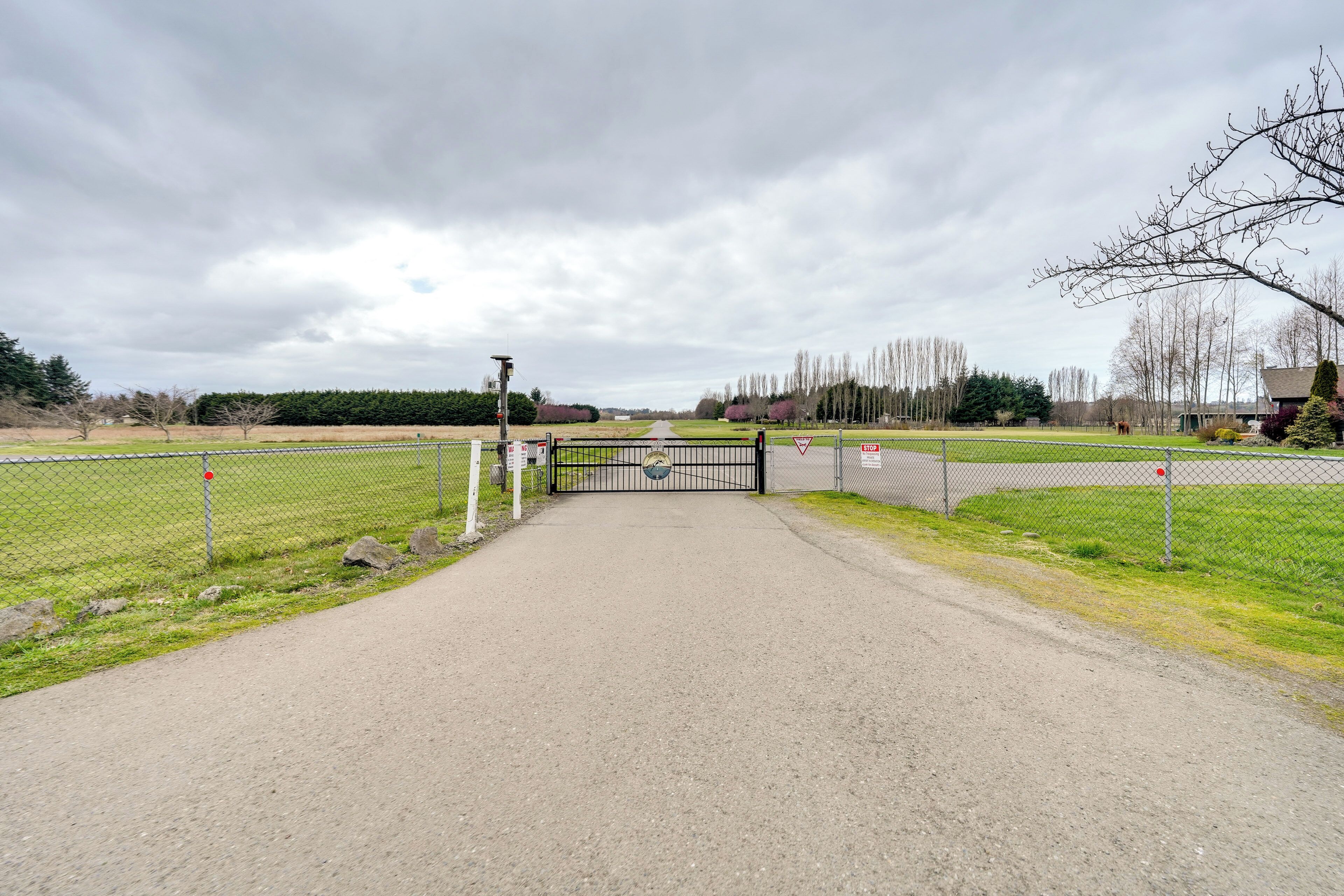 A gated entrance to a property with a paved path leading through it.