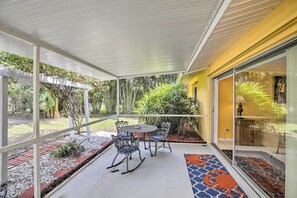 A covered patio area with a table and chairs, surrounded by plants and a garden. - Cape Coral Home w/ Yard < 1 Mi to Dtwn! (Cape Coral)