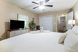 A bedroom with a bed, a television, a ceiling fan, a plant, and a door. - Pool Open Until Oct 15th! ~ 1 Mi to Dollywood (Pigeon Forge)