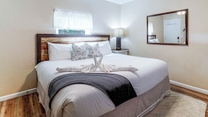 A hotel room with a bed, a nightstand, a lamp, a ceiling fan, a window with curtains, and a mirror on the wall. - Pool Open Until Oct 15th! ~ 1 Mi to Dollywood (Pigeon Forge)