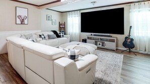 A living room with a sectional sofa, a flat-screen TV, a guitar, and a ceiling projector. - Pool Open Until Oct 15th! ~ 1 Mi to Dollywood (Pigeon Forge)