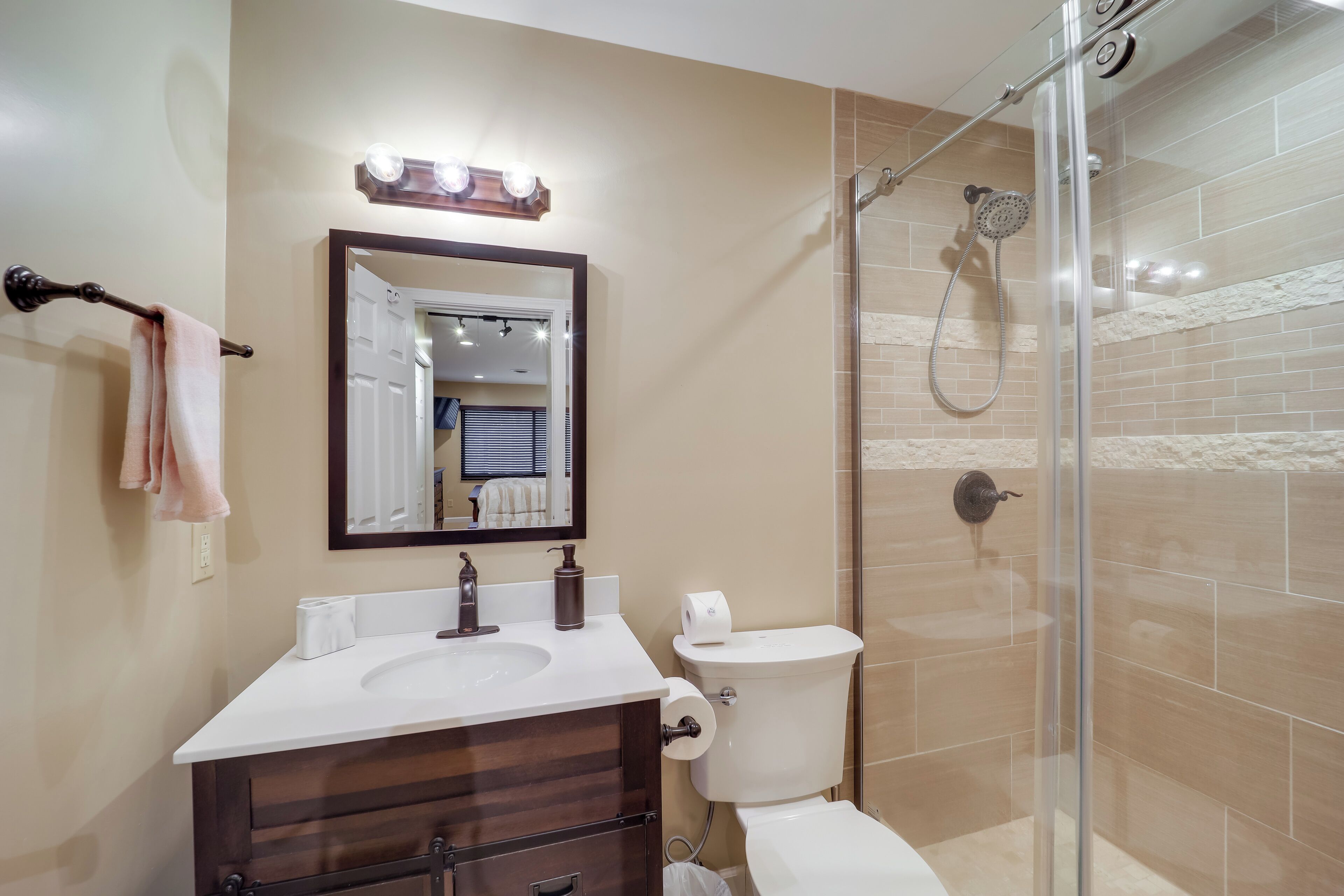 Un bagno con lavandino, specchio, servizi igienici e doccia vetrata.