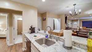 A modern kitchen with a granite countertop, stainless steel sink, and a chandelier. - Mtn-view Condo w/ Lookout Deck in Banner Elk! (Banner Elk)