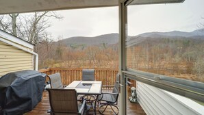 A covered deck with a table and chairs, overlooking a mountainous landscape. - Mtn-view Condo w/ Lookout Deck in Banner Elk! (Banner Elk)