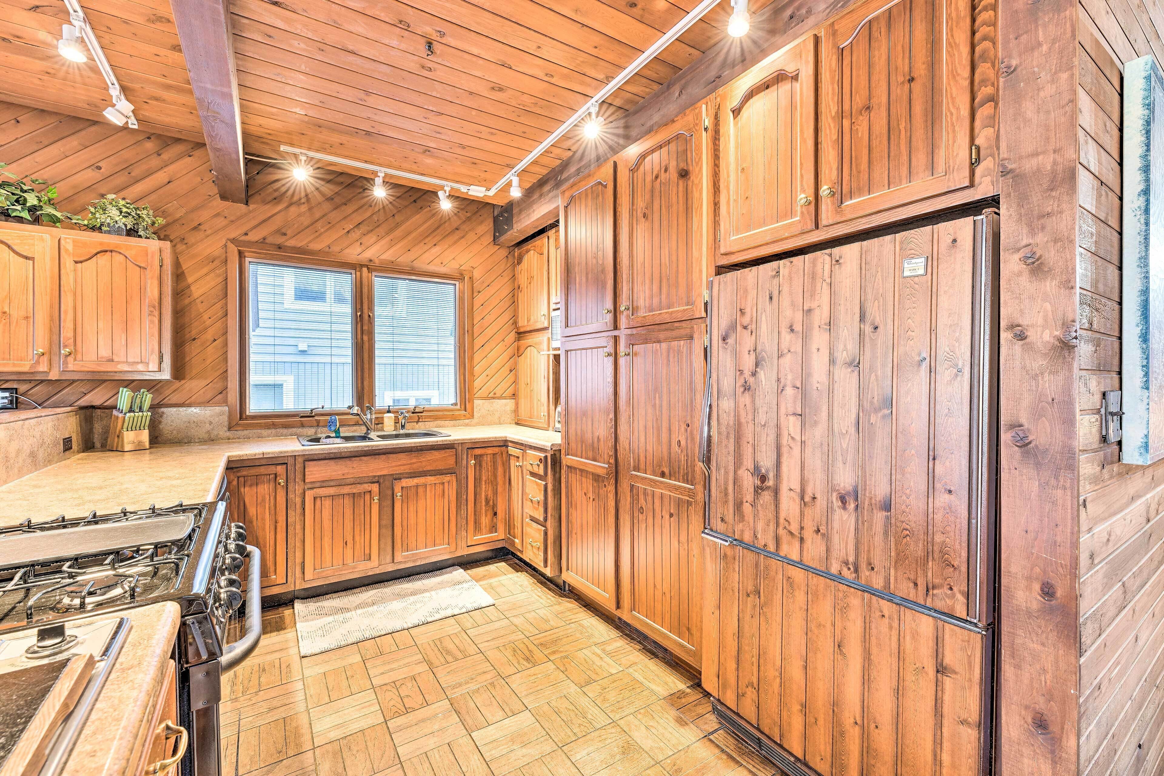 A kitchen with wooden cabinets, a stove, and a refrigerator.