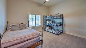 Une chambre à coucher avec un lit, un ventilateur de plafond, une fenêtre et un lit superposé.