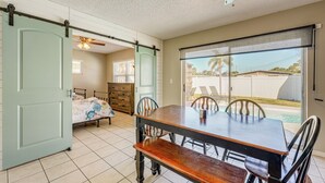 A dining area with a table and chairs, a ceiling fan, and a sliding door leading to another room. - Fire Pit! Family Getaway, 6 Mi to Beach Access (Largo)
