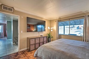 A bedroom with a large bed, a dresser, a mirror, and a window with curtains. - Beautiful Home w/ Pool Near Las Vegas Strip! (Las Vegas)