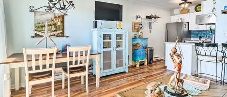 A dining area with a wooden table and chairs, a chandelier, and a cabinet with glass doors.