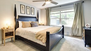 A bedroom with a bed, bedside tables, a ceiling fan, a window with curtains, and framed artwork on the wall. - Dtwn Winter Garden Home: 12 Mi to Disney! (Winter Garden)