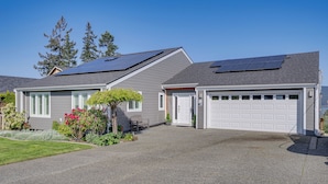 Une maison d’habitation dotée de panneaux solaires, d’un garage et d’une pelouse bien entretenue.